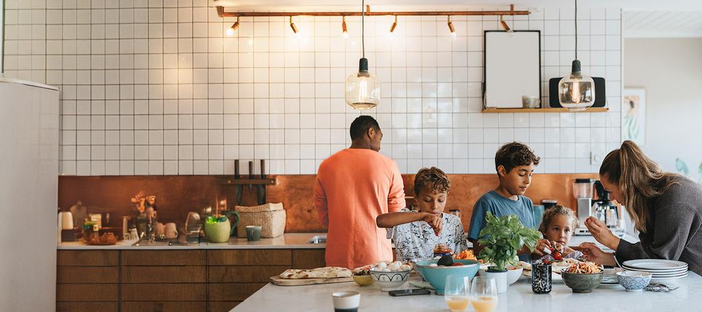 Gezin met man, vrouw en 3 kinderen is bezig in de keuken